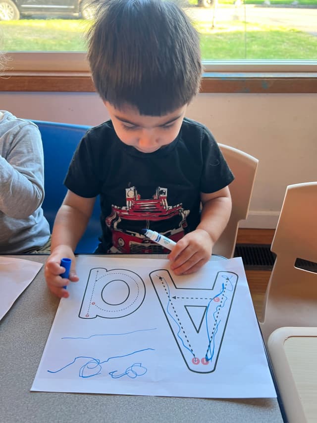  Child tracing letters on paper