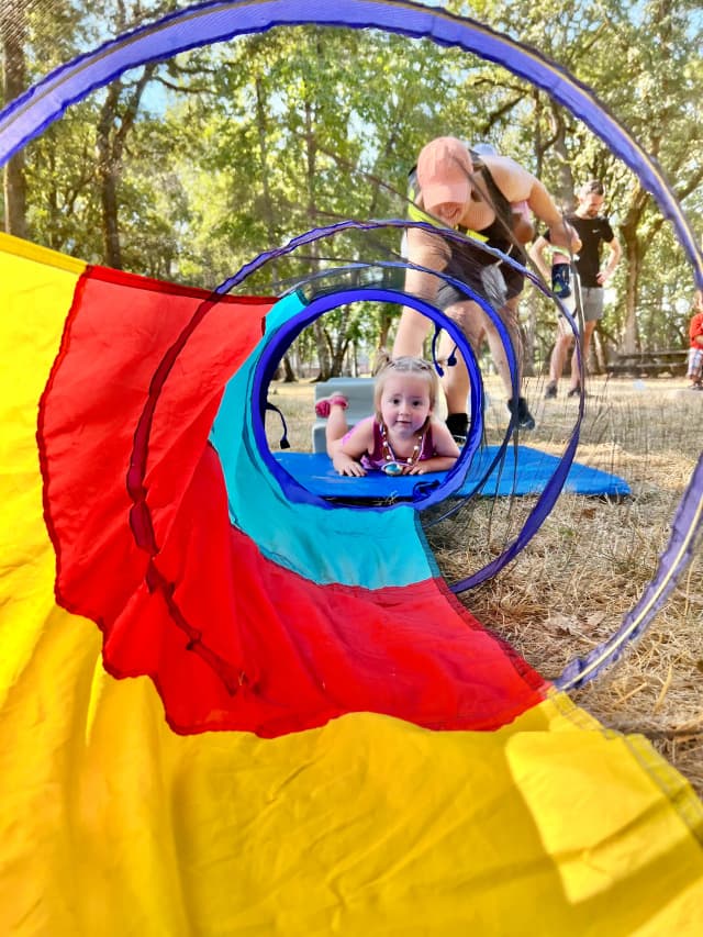  Child crawling through colorful tunnel